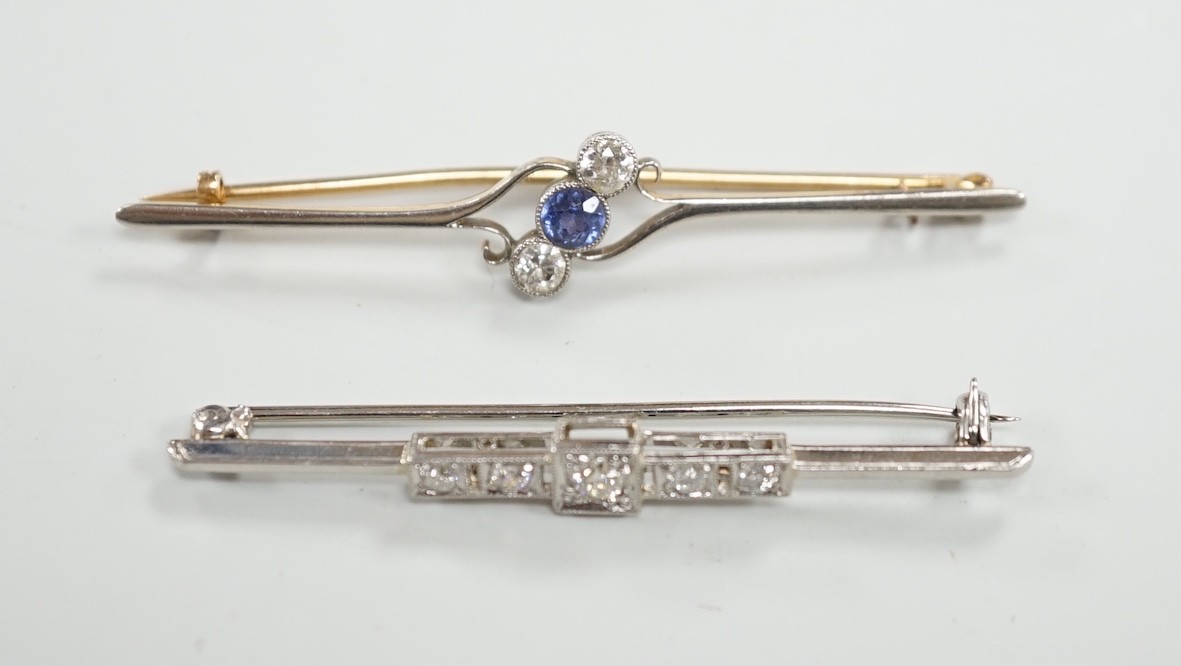 An early to mid 20th century white metal and five stone diamond set bar brooch, 50mm and a similar yellow metal, two stone diamond and single stone sapphire set crossover bar brooch, gross weight 7.1 grams.